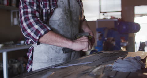 Craftsman Carring Out Blade Sharpening in Workshop