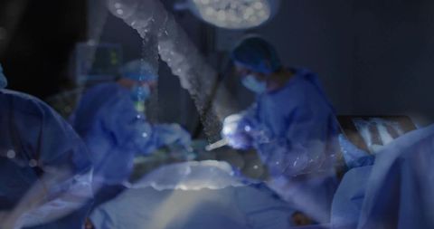 Surgical team performing complex operation in operating room with x-ray monitor