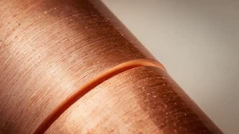 Macro Video Showing Copper Cylinder Turning on Lathe with Fine Concentric Machining Texture