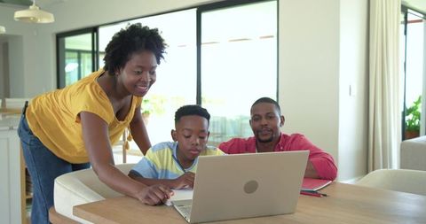 African american parents guiding son on laptop at home family learning and togetherness