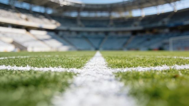 Center line running along soccer pitch showing turf texture and stadium depth