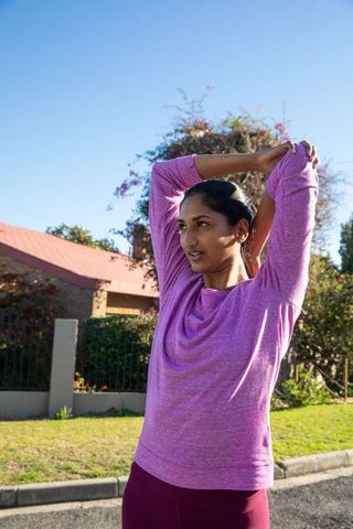 Active Woman Stretching Outdoors in Suburban Setting