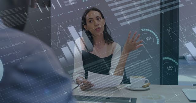 Businesswoman explaining financial data on a digital screen in a modern office. High-tech overlay of financial charts and analytics. Useful for business discussions, financial analysis, corporate presentations, collaborative work environments, and professional consulting settings.