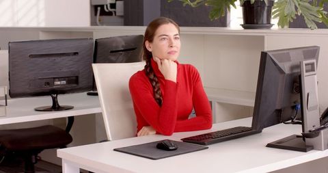 Businesswoman Contemplating at Desk in Modern Workspace