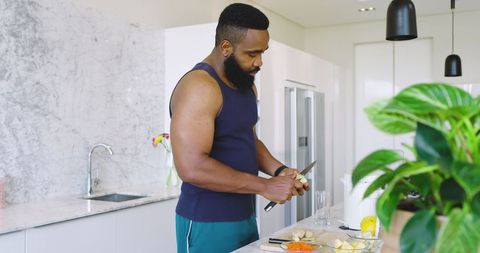 African American Man Preparing Fresh Vegetables in Modern Kitchen