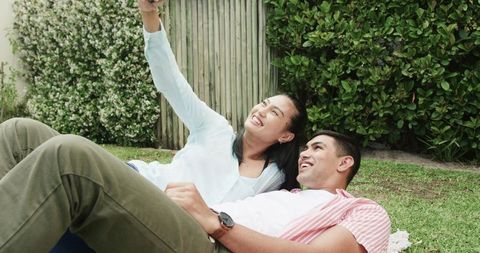 Happy Young Couple Taking Selfie on Grass Outdoors