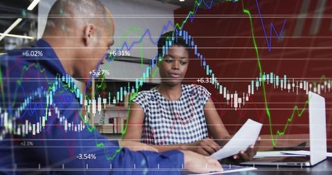 Business team analyzing stock charts and financial data during collaborative office meeting