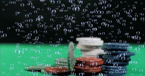 Air bubbles surrounding casino chips on green casino table