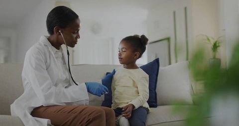 Doctor performing medical checkup on girl at home