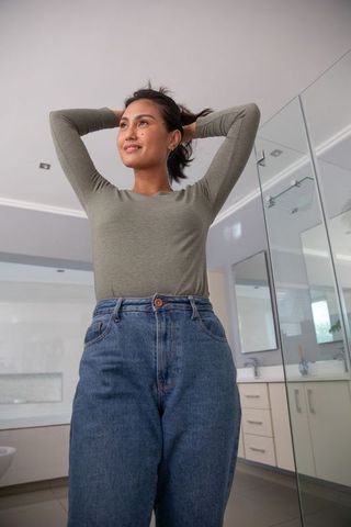 Woman Gathering Hair in Modern Bathroom for Relaxing Routine