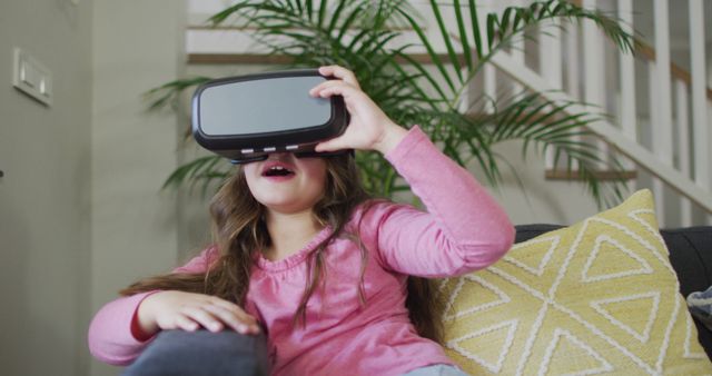 Young girl experiencing virtual reality on couch - Download Free Stock Images Pikwizard.com