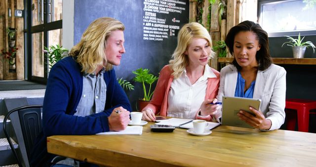 Team Brainstorming Together Around Tablet in Coffee Shop - Download Free Stock Images Pikwizard.com