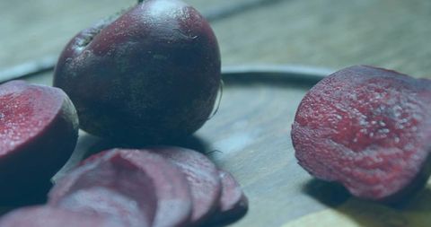 Fresh beetroot and sliced rounds resting on wooden cutting board for rustic kitchen decor