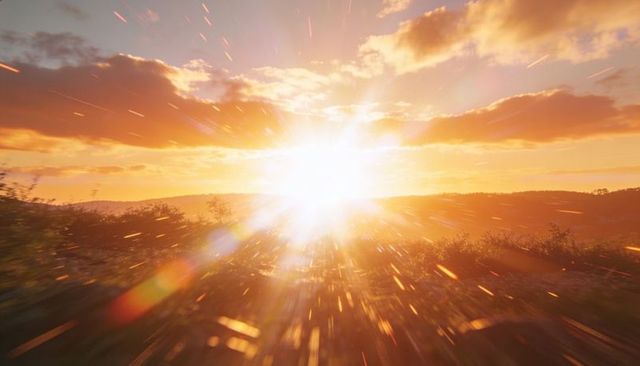 Golden-hour sunburst bursting over rolling hills with dramatic radial lens flares