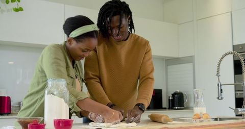 African American Couple Baking Bread Together on Modern Kitchen Island, Kneading Dough
