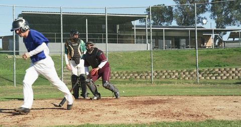 Baseball player sprinting from home plate during game