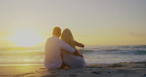 Romantic Couple Watching Sunset on Beach