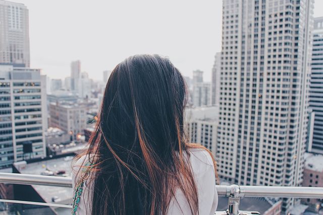 Woman Admiring Urban Cityscape from Rooftop at Dusk - Download Free Stock Images Pikwizard.com