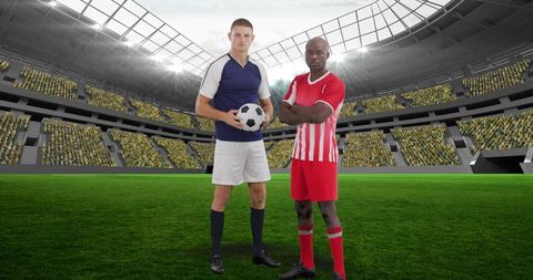 Two soccer players standing on field in stadium holding soccer ball