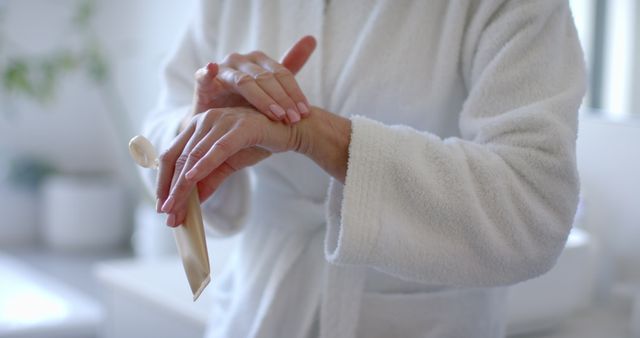 Mature Woman in Robe Applying Hand Cream in Home Bathroom - Download Free Stock Images Pikwizard.com