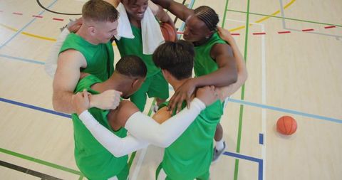 High school basketball team huddling on court showing teamwork and pregame motivation