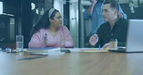 Team discussing strategy in glass conference room during collaborative planning meeting