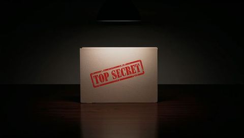Top secret manila folder under spotlight on dark wood table dramatic confidential dossier