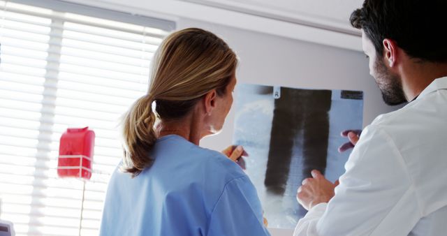 Doctors are examining and discussing an X-ray in a medical office. This can be used for articles, blogs, or advertisements related to healthcare, medical consultations, teamwork in healthcare settings, and diagnostic processes.