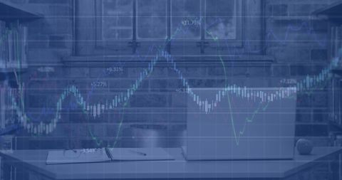 Overlay of Financial Graphs on Laptop in Modern Office Environment