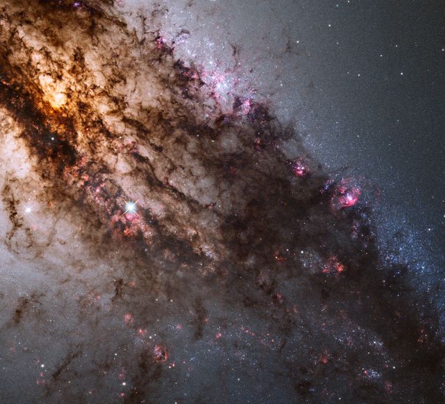Detailed view of Centaurus A by Hubble's Wide Field Camera 3 showing dark dust lanes, bright young blue star clusters, and evidence of a past galactic collision. Ideal for use in educational materials, articles on astronomy, posters of deep space imagery, or as a visual aid in scientific presentations.