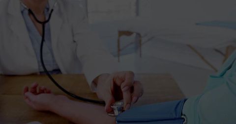 Doctor Measuring Blood Pressure of Patient in Medical Office
