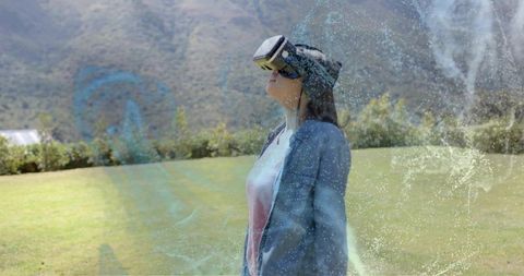 Teen exploring virtual reality on mountain meadow wearing vr headset, hologram effects
