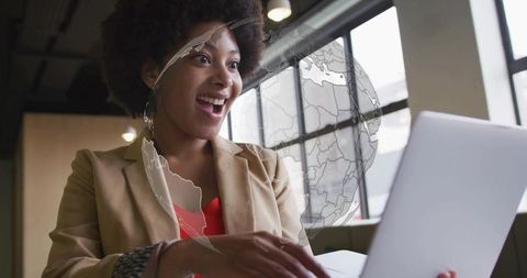 Smiling Businesswoman Working on Laptop with Digital Globe Overlay