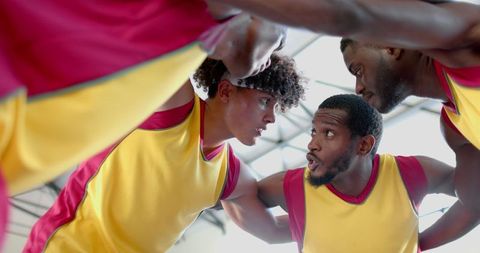 Focused basketball team strategizing during game huddle