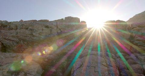 Sunrise over mountain peaks with radiant lens flare