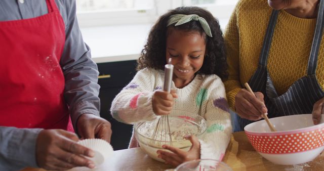 Image of happy african american granddaughter baking with grandparents in kitchen. Family, domestic life and togetherness concept digitally generated image.
