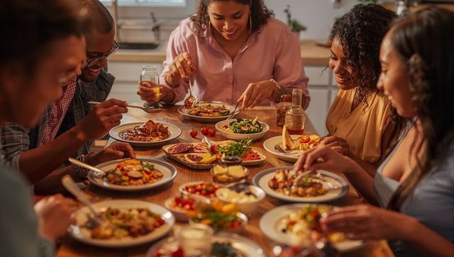 Friends Sharing Homemade Dinner Around Wooden Table, Enjoying Casual Home Gathering