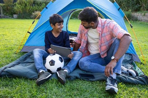 Father and Son Bonding in Nature with Tablet and Soccer Ball