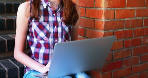 Teenage Student Using Laptop Outdoors for Study
