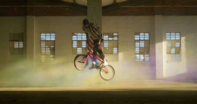 BMX Rider Performing Stunt in Abandoned Warehouse with Colored Smoke - Download Free Stock Images Pikwizard.com