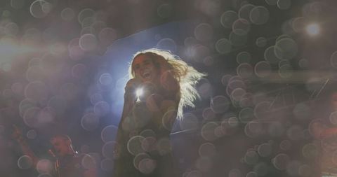 Energetic Woman Singing in Concert with Captivating Stage Lights