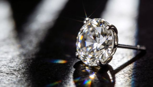 Brilliant-cut diamond stud earring sparkling with starburst and rainbow reflections