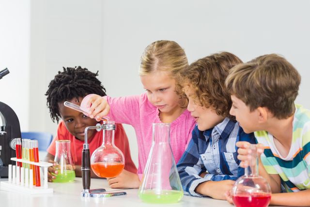 Group of children conducting a chemistry experiment in a school laboratory. They are using beakers, test tubes, and a microscope, demonstrating curiosity and teamwork. Ideal for educational materials, science-related content, and promoting STEM education.