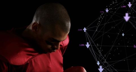 Bowing football player holding ball wearing red jersey eye-black with purple network