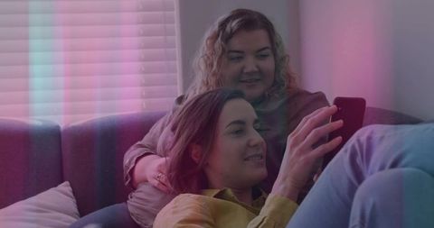 Couple Relaxing on Sofa Using Smartphone in Cozy Living Room