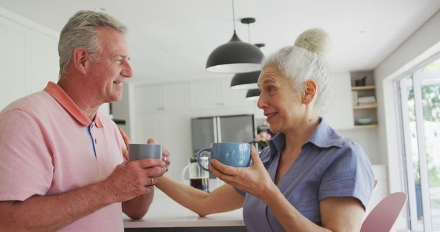 Happy caucasian senior couple with coffee talking together in kitchen. active and healthy retirement lifestyle at home.