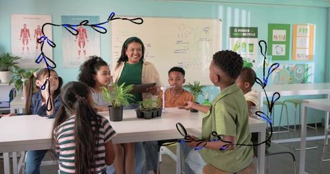 Teacher guiding students in hands-on plant science lesson with seedlings and tablet