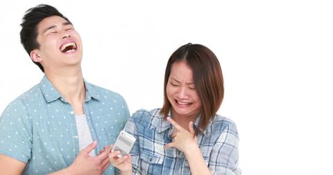 Young Couple Reacting Hilariously to Smartphone Content
