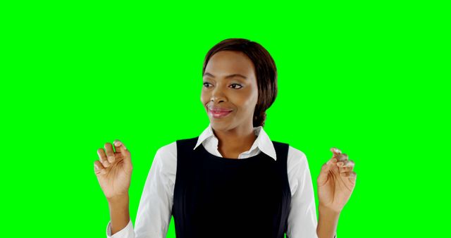 Professional woman in business attire confidently smiling and gesturing against green screen background. Ideal for workplace, business, or presentation-themed projects. Perfect for use in marketing, corporate videos, or training materials.
