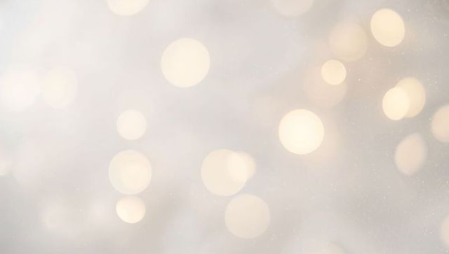 Soft Golden Bokeh Lights on Pale Beige Background with Subtle Sparkle and Ambient Warmth
